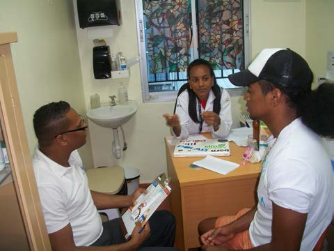 Photo of client receiving services at Clinica de Familia La Romana with health providers Riqui Rosario and Dr. Wendy Galvez. Photo: Carol Brito